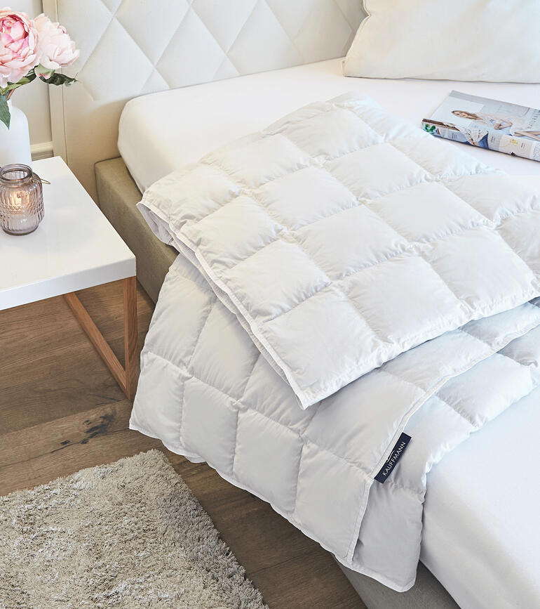 Leichte Eiderdaunendecke auf einem Bett mit Kissen