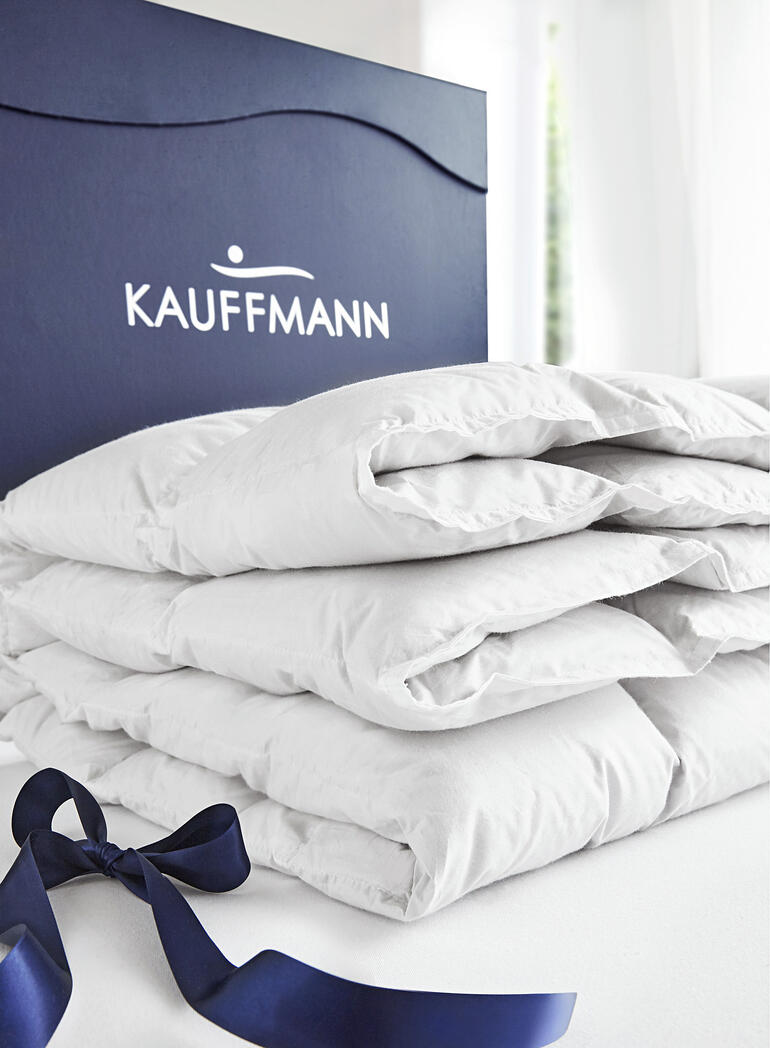 Das bauschige Eiderdaunen-Vlies bietet unübertrefflich leichte Wärme. Eiderdaunendecke in einer Verpackung mit Kauffmann-Label