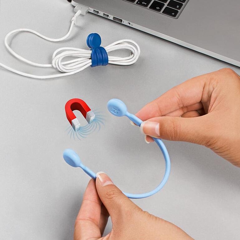 Hände halten einen blauen Magnet-Kabelbinder und zeigen ihn neben aufgerolltem Kabel.