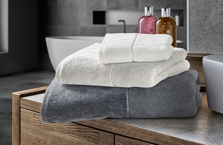 Helle Frottiertücher in Weiß und Grau auf einem Badunternehmen