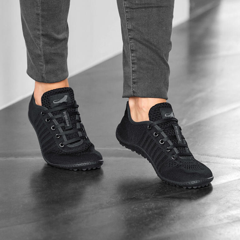 Barfuß-leguano Sneaker in Schwarz, getragen von einer Person.