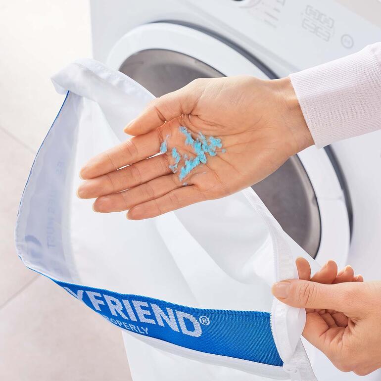 Die abgebrochenen Plastik-Fasern lagern sich im Waschbeutel ab und können einfach entfernt werden. Händische Entnahme von Mikroplastik aus dem STOP! Wäschebeutel