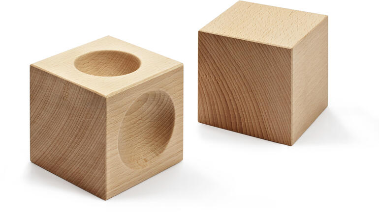Zwei Holzwürfel, einer mit Aussparung für Nüsse.