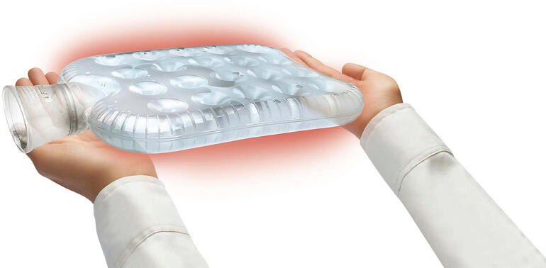 Hände halten eine transparente Waben-Wärmflasche.