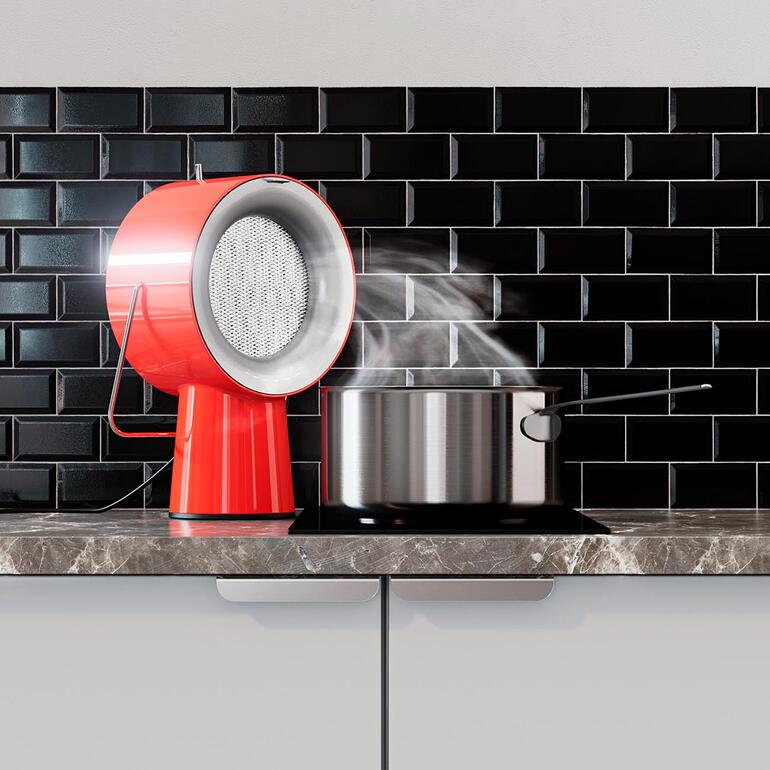 Rote AirHood™-Garäte mit Dampfwolke über einem Kochtopf auf einer Arbeitsfläche.