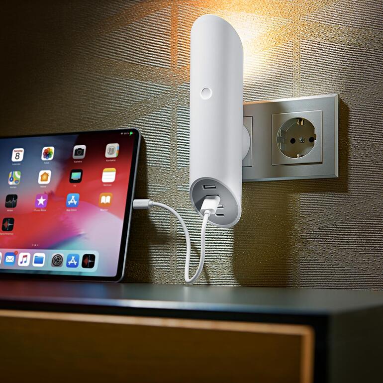 Steckdosen-Leuchte mit 4 USB-Ports, die in einer Wandsteckdose eingesteckt ist.