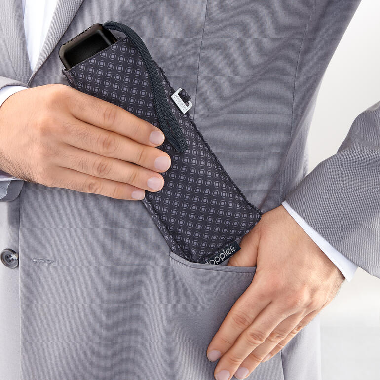 Kaum größer als ein Brillenetui, passt Ihr Minischirm spielend in die Jackentasche. Hände stecken einen Carbonstahl-Taschenschirm in die Anzugtasche.