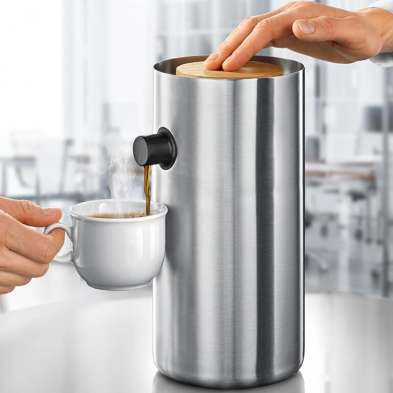 Design-Pumpkanne aus Edelstahl mit Dampf und Tasse.