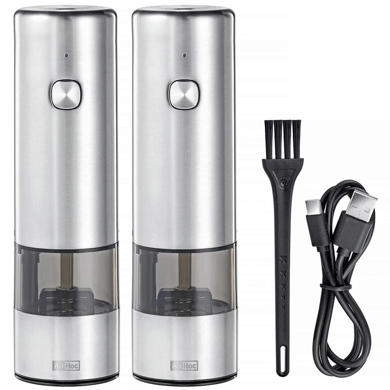 Zwei Akku-Gewürzmühlen mit USB-Ladekabel und Bürste nebeneinander.