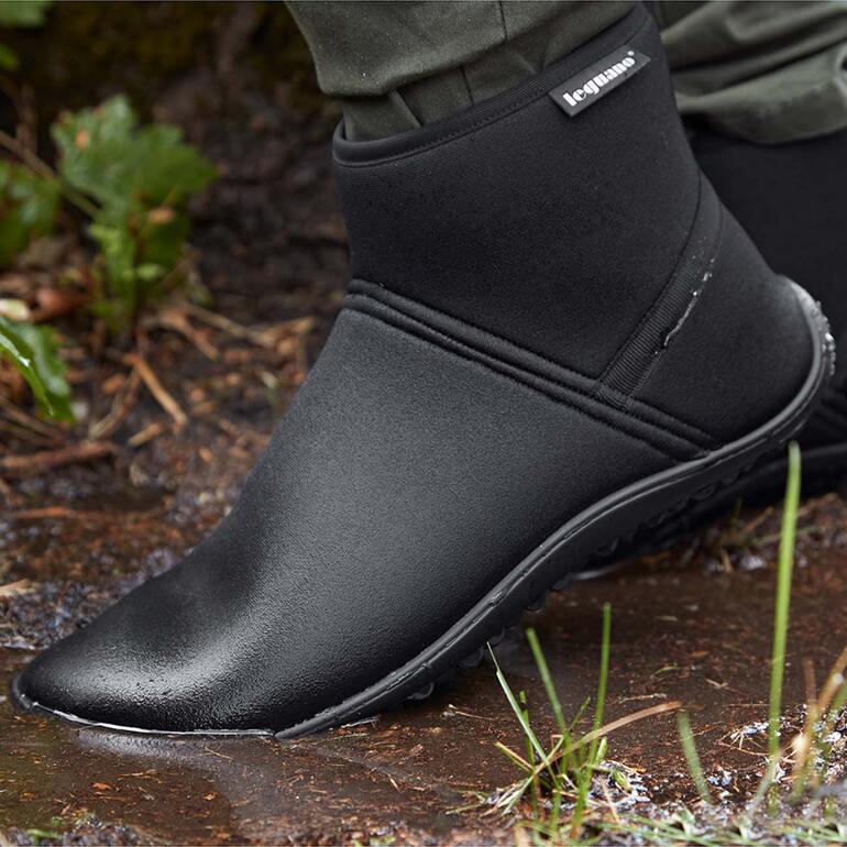 Bein in leguano Thermo-Schlupf-Stiefelette auf nassem Boden