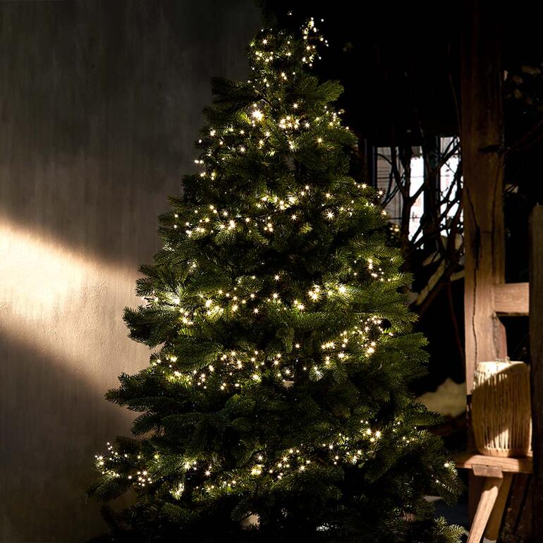 Solar-Lichterkette leuchtet auf einem Christbaum.