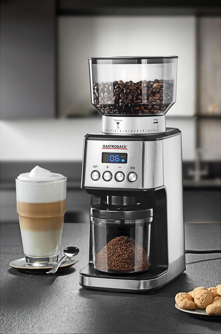 Gastroback Design-Kaffeemühle mit Kaffeetasse daneben.