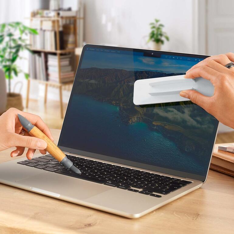 Hände benutzen einen 3-in-1 Mobilgeräte-Reiniger auf einem Laptop