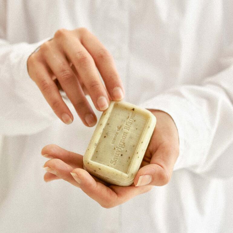Wahlweise in den Sorten Merlot oder Sauvignon Blanc erhältlich. Person hält die Seife The Real Wine Soap® in der Hand.
