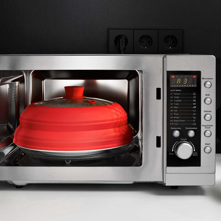 Rote Universal-Abdeckung in Mikrowelle mit Timer