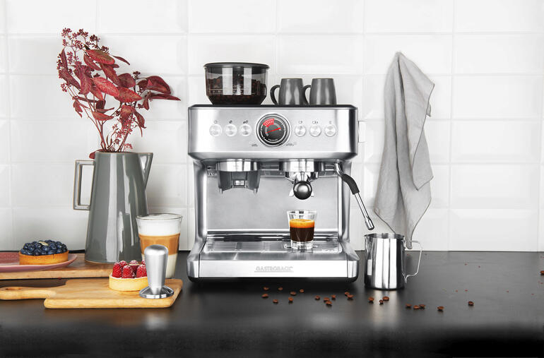 Design-Siebträgermaschine Advanced Duo mit Kaffeetasse und Zubehör.
