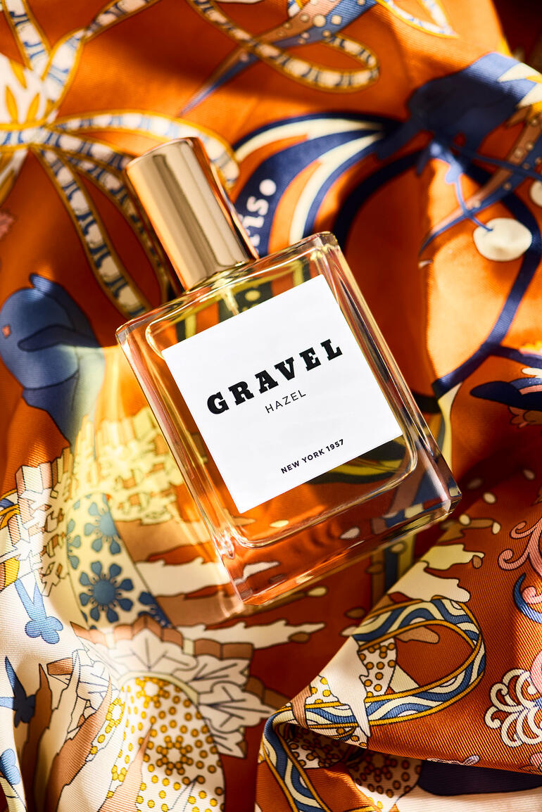 Gravel Hazel Eau de Parfum auf einem bunten Stoff