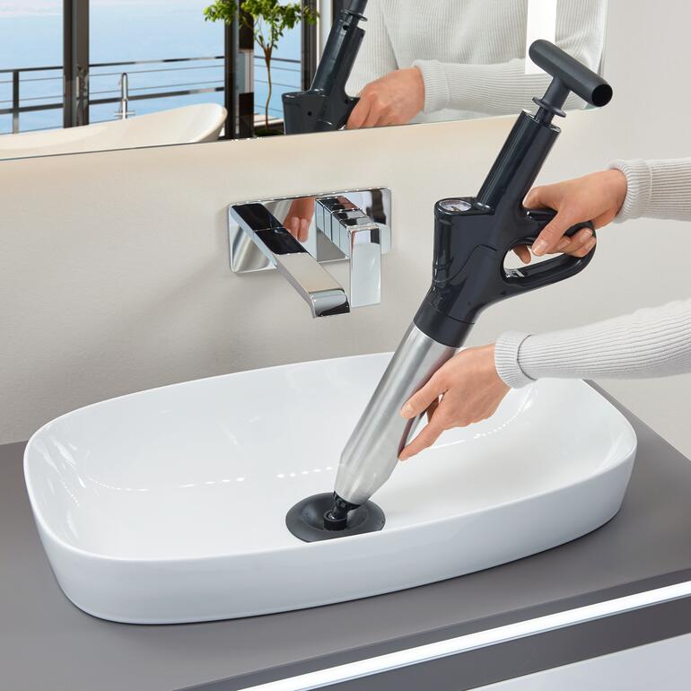 Person nutzt einen 6 bar-Abflussreiniger im Waschbecken