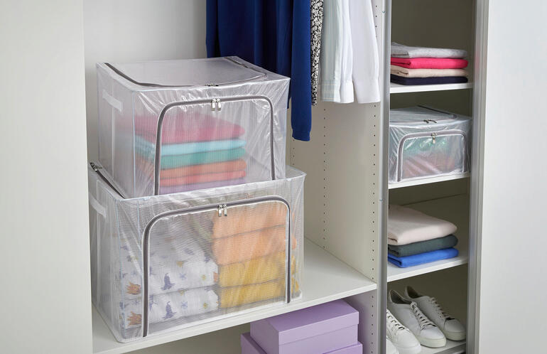 Zwei faltbare Aufbewahrungsboxen in einem Schrank mit buntem Inhalt.