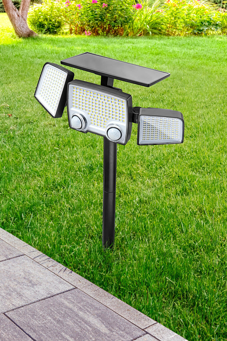 Solar-Sicherheitsleuchte im Garten auf einem Standfuß.