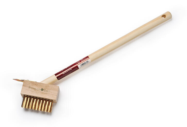 Unkraut-Fugenbürste mit langem Holzgriff und gebogenen Borsten.