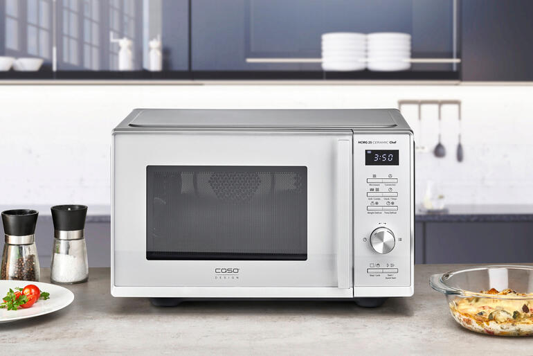 Drei-in-Eins-Mikrowelle auf einer modernen Küchenarbeitsplatte mit Zutaten.