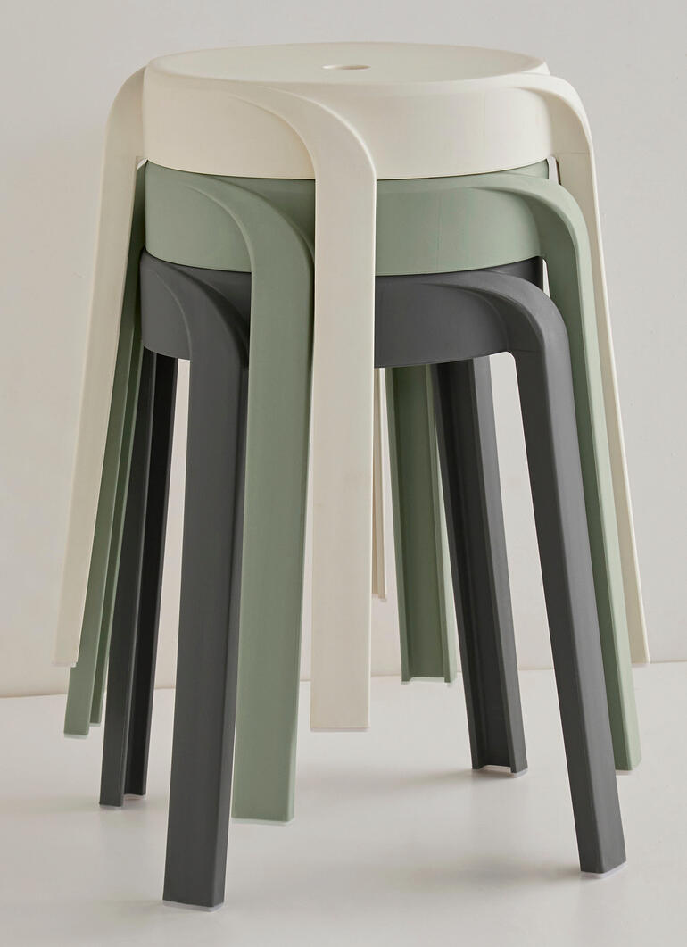 Drei Stapelhocker in Creme, Olivgrün und Dunkelgrau gestapelt.
