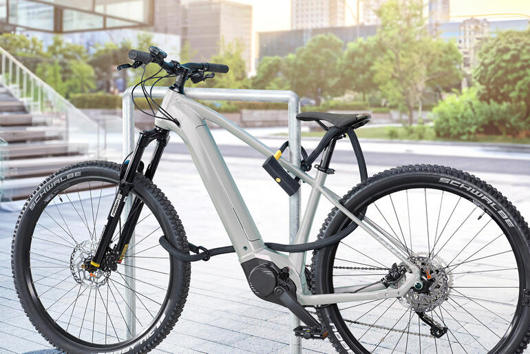 Bügelschloss mit Sicherheitsseil an einem Fahrrad montiert.