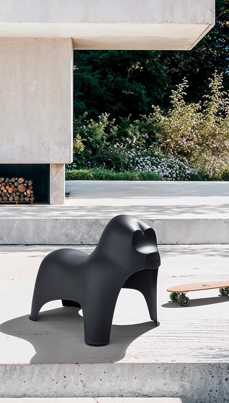 Der widerstandsfähige Gorilla-Hocker ist auch im Außenbereich ein origineller Blickfang. Schwarzer Gorilla-Hocker steht auf einer Terrasse neben Skateboard.
