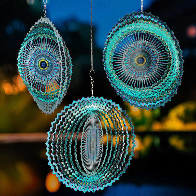 Schon ein kleiner Luftzug bewirkt eine Drehbewegung und lässt von Sekunde zu Sekunde eine neue interessante Optik entstehen. Mandala-Windspiel in der Nacht mit leuchtenden Farben.
