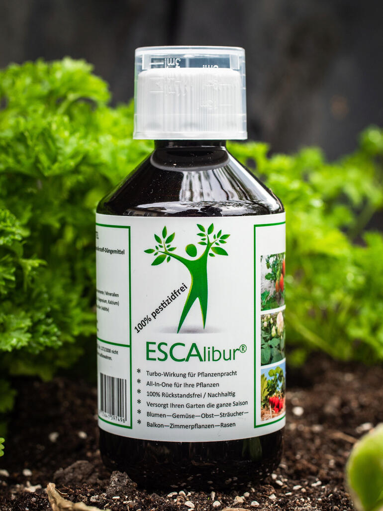 ESCAlibur® Pflanzennahrung in Flasche, 250 ml vor grünem Pflanzenhintergrund.