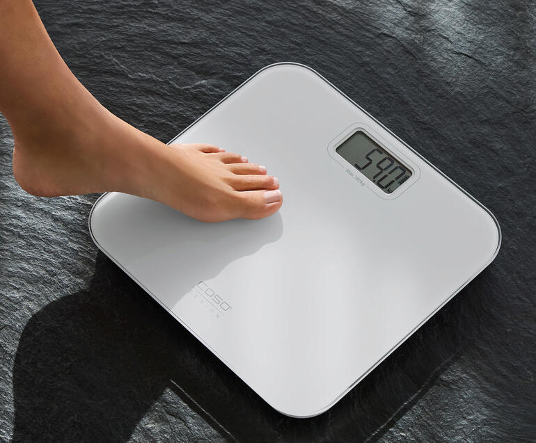 Füße stehen auf einer batterielosen Design-Personenwaage