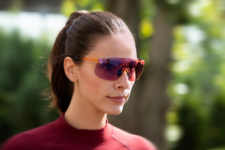 Unisex-Modell: auch für Damen geeignet. Frau in Sportbekleidung trägt eine Sonnenbrille.