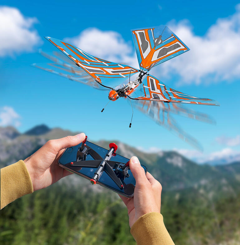 Ferngesteuertes Modell eines fliegenden Insekts mit orangefarbener Flügelstruktur.