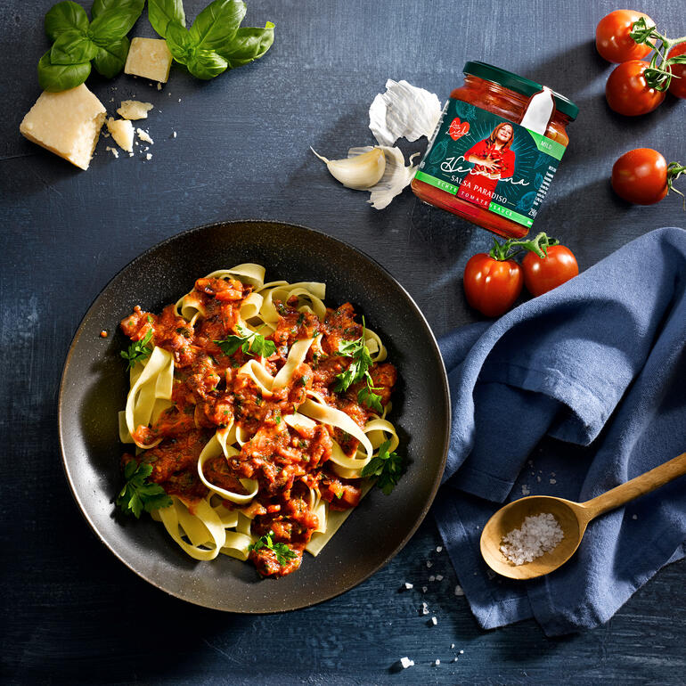 Pasta mit Hermina Salsa Paradiso, serviert in einer Schale mit Tomaten.