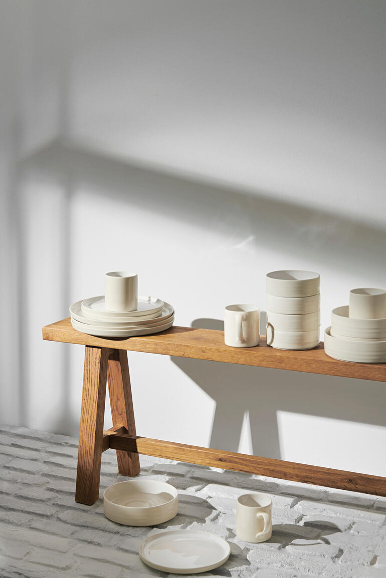 Reglaze Essteller 6er-Set auf einem Holztisch dekorativ gestapelt.