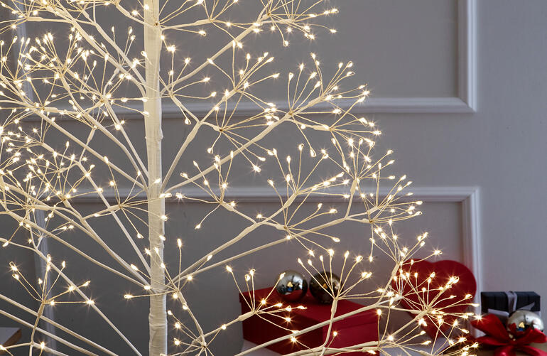 Nahaufnahme des Dolden-Lichterbaums mit warmen Lichtern im Innenraum