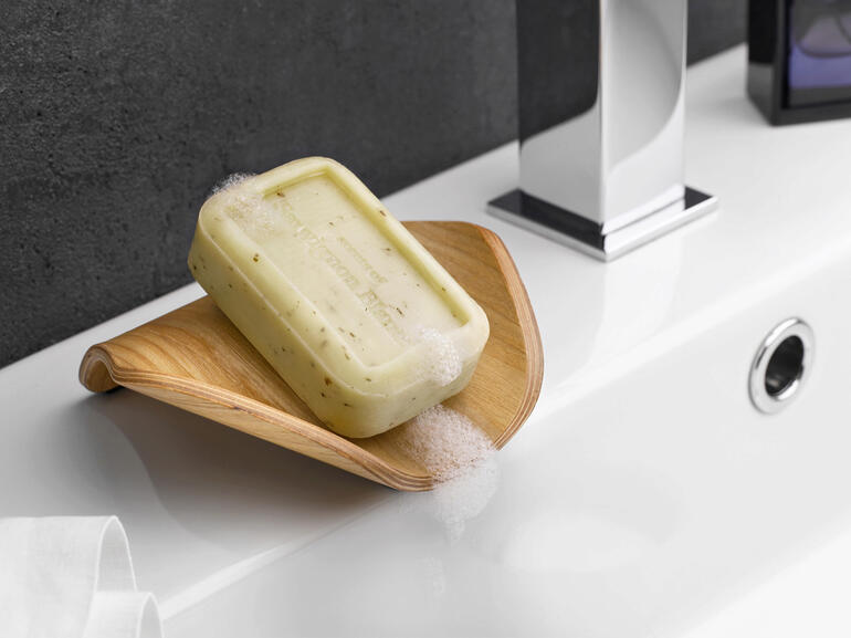 Holz-Seifenschale mit Seife, auf einem Badezimmerwaschtisch