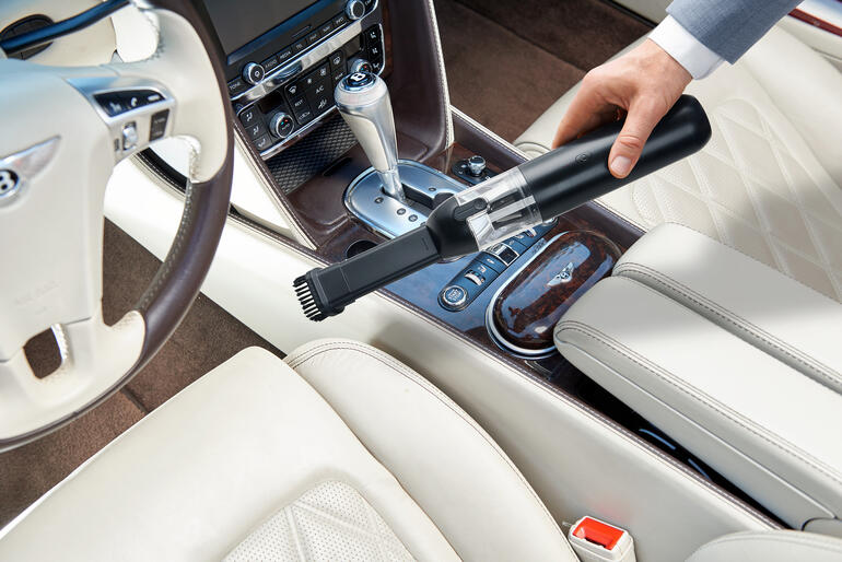 2-in-1 Akkusauger wird im Auto verwendet, um den Innenraum zu reinigen.