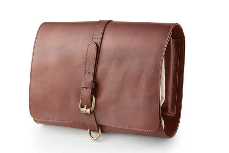 Büffelleder-Kulturtasche geschlossen mit Schnalle, auf weißem Hintergrund.