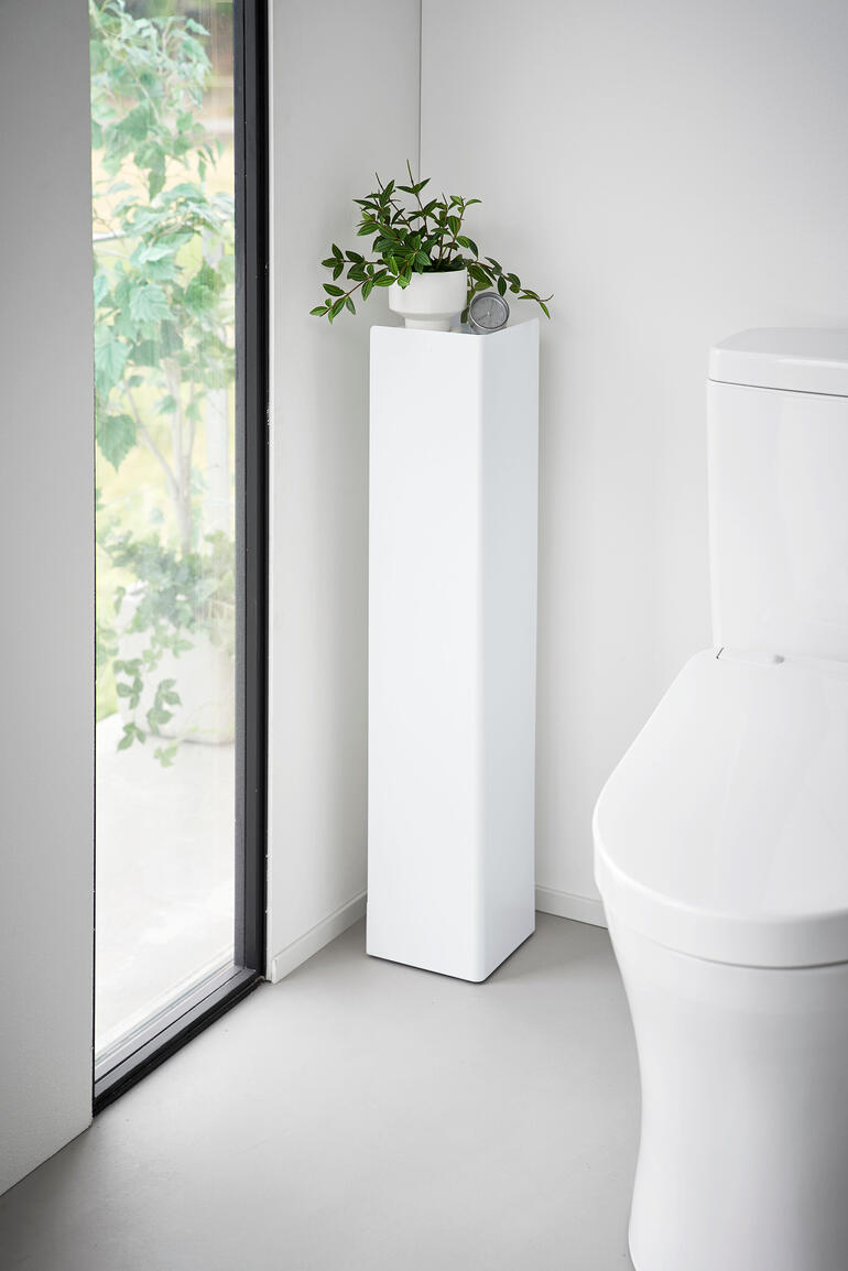 Weißer WC-Organizer mit Pflanze und Dekoration in der Ecke
