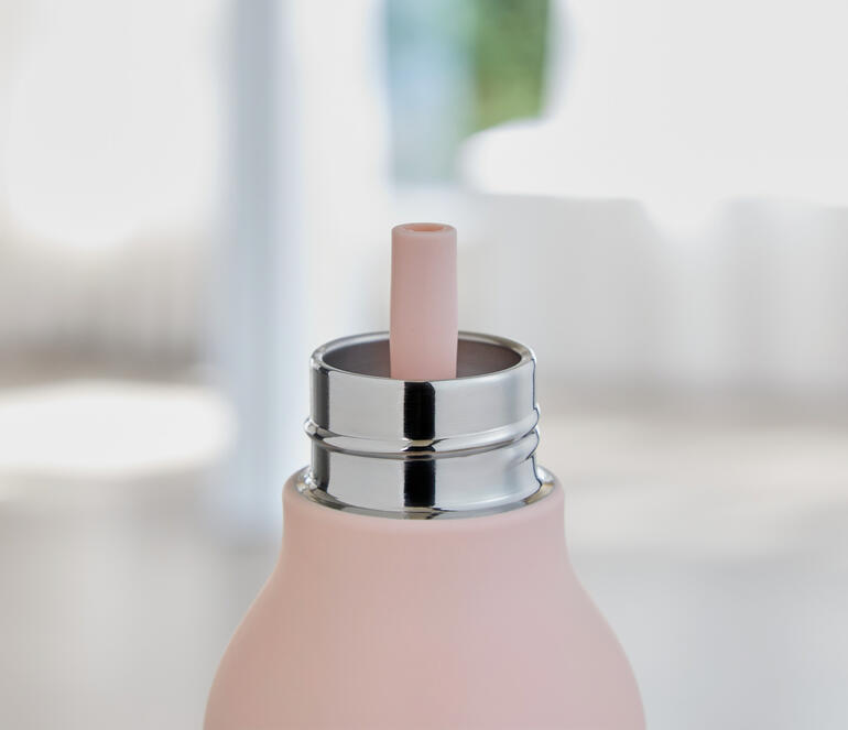 Nahaufnahme von Wasserflasche mit rosa Füllung und Trinkhalm