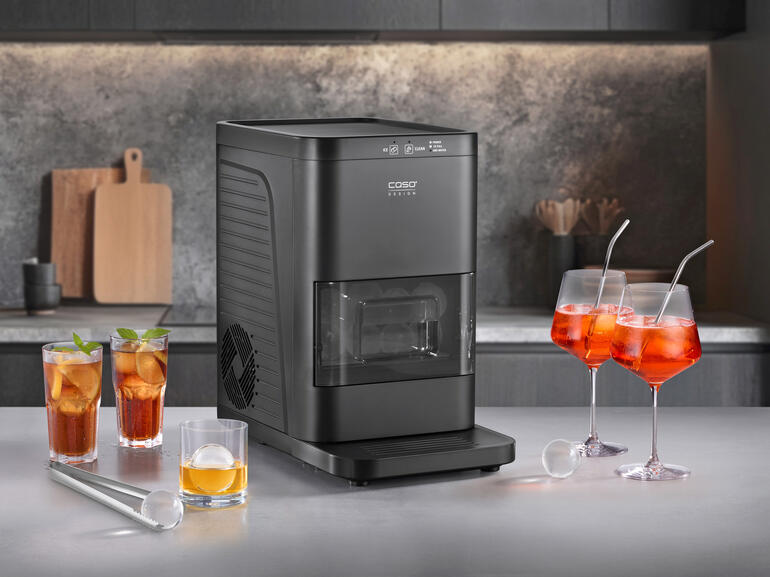 Eiskugelbereiter mit Cocktails und Gläsern auf einem Tisch.