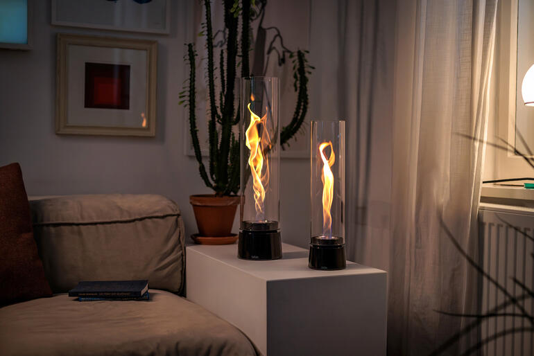 Zwei flammenförmige Lampen im Wohnbereich strahlen Licht aus.