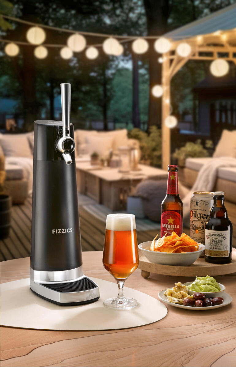 Bier-Zapfanlage auf einem Tisch mit Gläsern und Snacks im Hintergrund.
