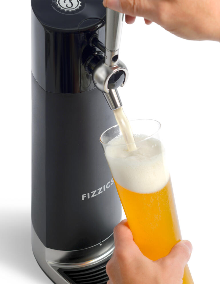 Hände zapfen Bier aus der Bier-Zapfanlage in ein Glas.