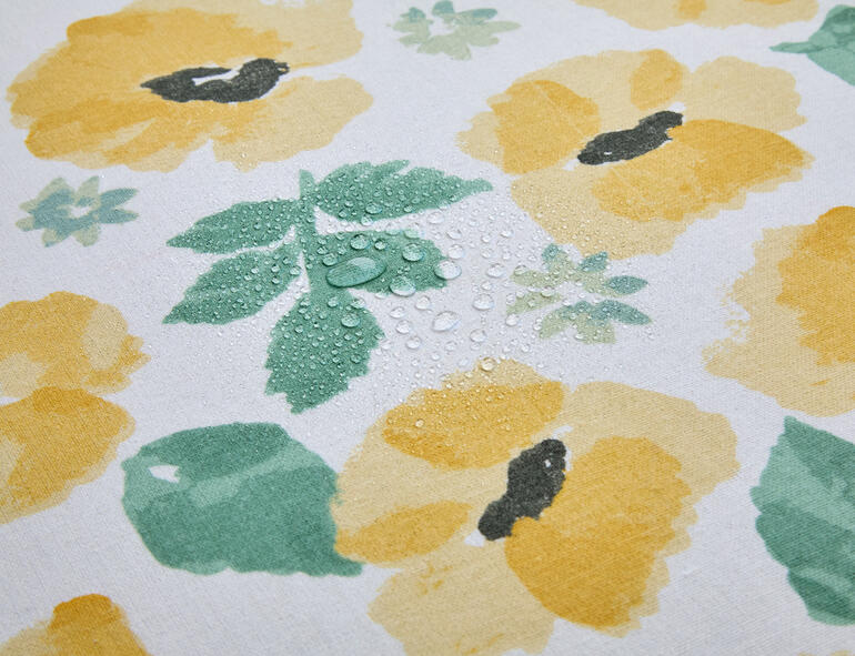 Wassertropfen auf einer Aquarell-Tischdecke.