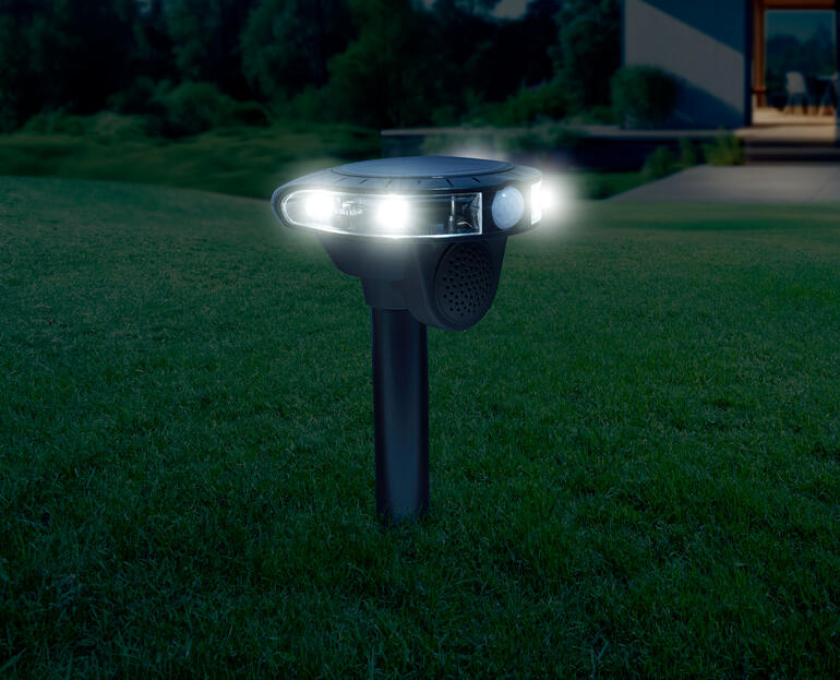 Elektronische Tierabwehr bei Nacht, leuchtet mit zwei weißen Lampen.