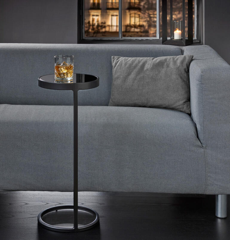 Mini-Beistelltisch mit einem Glas auf dem Tisch.