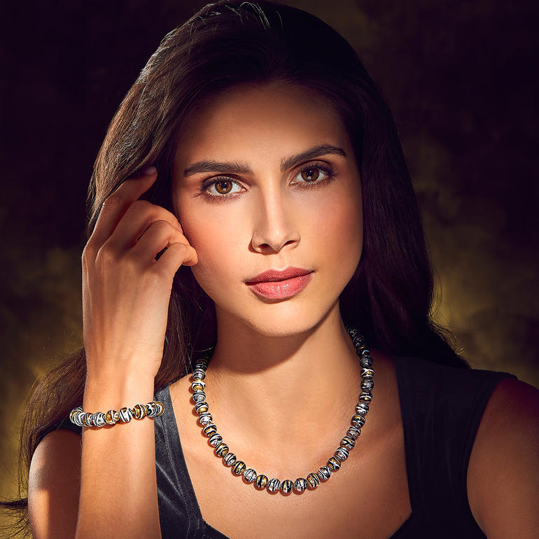 Murano-Perlenarmband und -collier an einem Handgelenk und um den Hals einer Frau.